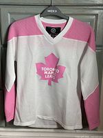 Front view of pink and white Toronto Maple Leafs jersey