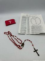 Rosary, red pouch, instruction leaflet overview