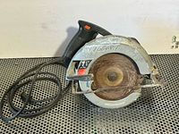 Left side view of Skil circular saw showing blade guard, handle and cord