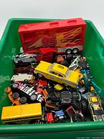 Overall view of green bin filled with assorted toy vehicles