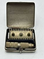 razor disassembled in open case showing handle, base plate, top cap