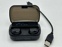 earbuds seated in open charging case with cable alongside