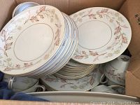 Assortment boxed showing plates, cups, sugar bowl, creamer with brown and beige leaf pattern with gold trim.