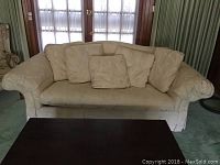 Front-facing view of the tan Vanguard sofa showing the upholstery, seat cushion, and back pillows.