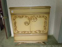 Full view of the chest of drawers showing the top drawer, the two front cabinet doors with unique carved design, and the base