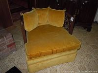 Full front view of vintage gold velvet upholstered club chair showing plush cushions and carved wooden backrest.