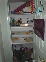 Photo showing shelves with cleaning products, gift wrap rolls, and other supplies.