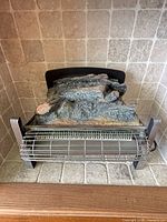 Front view of electric fireplace insert with grill and faux logs
