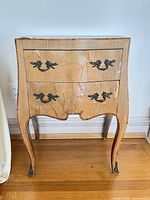 Front view showing two drawers, bombe shape, veneer damage