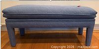 Side view of blue floral matelassé upholstered ottoman bench