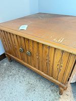 Front and side view of square oak veneer coffee table showing carved panels and brass knobs