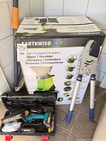 Boxed Earthwise chipper/shredder alongside lopper and chainsaw case