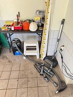 Overall lot showing vacuums, step stool, leveling rod and table of tools