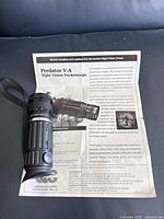 Night vision monocular lying on specification sheet