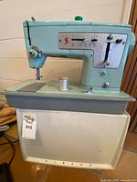 Front view of Singer sewing machine on base with thread spool