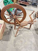 Side view showing full wooden spinning wheel and large drive wheel