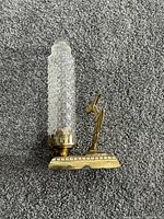 Front view showing pressed glass shade and metal dancer on base