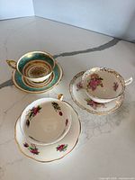 Three teacup and saucer sets showing patterns and colours