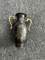 Front view of etched brass vase with floral pattern and handles