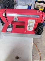 Front view of Brother Festival 451 sewing machine with foot pedal and cords on case base