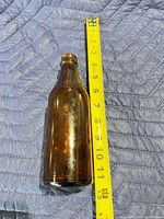 Bottle beside tape measure showing 10.5 in length