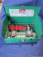Open stove showing burners, grate and red fuel tank