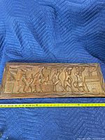 Front view of entire carved panel with measuring tape showing length