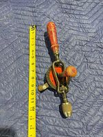 Full view showing drill beside tape measure approx 13 in