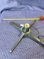Top view of green plastic electric tree stand with measuring tape for scale