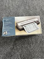 Retail box showing Mainstays hot and cold laminator and sample laminated document