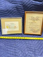 Front view of both framed prints with measuring tape for scale