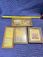 Front view of all four framed prints with tape measure for scale