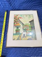 Front view of framed artwork with tape measure showing dimensions
