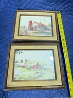 Front view of both framed prints with measuring tape for scale