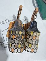 Front view of both pendant lights showing glass discs and metal hoods