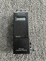 Front view showing display, speaker grille, model marking