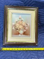 Front view of framed Rossy floral painting with measuring tape showing width