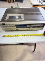 Front and top of Sanyo VCR 3900 with measuring tape for scale