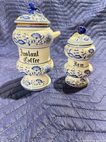 Front view of both ceramic canisters showing labels and floral pattern