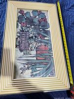 Full view of framed floral print with measuring tape showing length