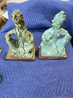 Front view of both green patina cast metal Asian figurines on bases