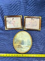Front view showing all three framed prints with measuring tape for scale