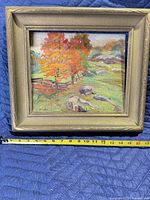 Front view of framed oil landscape painting with measuring tape