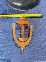 Full view of spinning wheel bobbin assembly beside tape for scale
