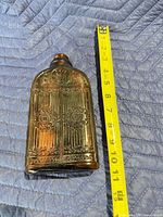 Front view showing ornate embossed design and tape measure for height context