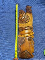 Front view showing carved details and tape measure indicating length ~25 inches
