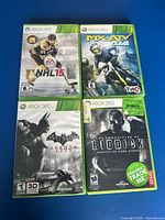 Front view of four Xbox 360 game cases: NHL 15, MX vs. ATV Alive, Batman Arkham City, Chronicles of Riddick