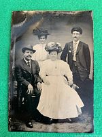Front view of tintype showing four subjects in formal attire