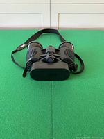 Front view showing objective lenses, Bushnell logo and attached strap