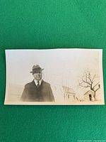 front view of vintage snapshot photograph showing man in fedora and formal attire outdoors